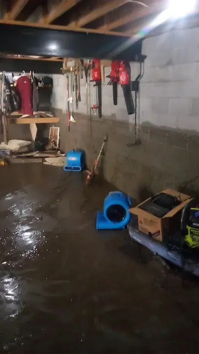 Flooded unfinished basement floor with air movers set out